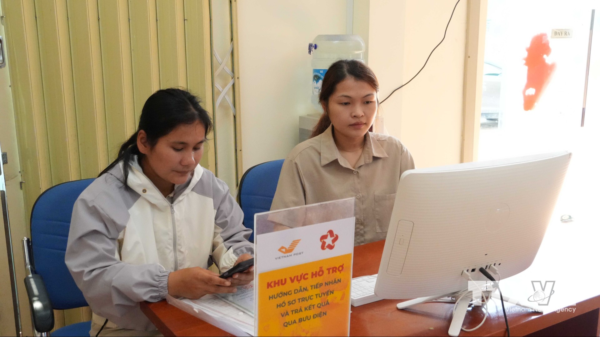 Thành viên Tổ công nghệ số cộng đồng xã Tu Mơ Rông, tỉnh Quảng Ngãi, hướng dẫn người dân nộp hồ sơ thủ tục hành chính trực tuyến. (Ảnh: Dư Toán/TTXVN)